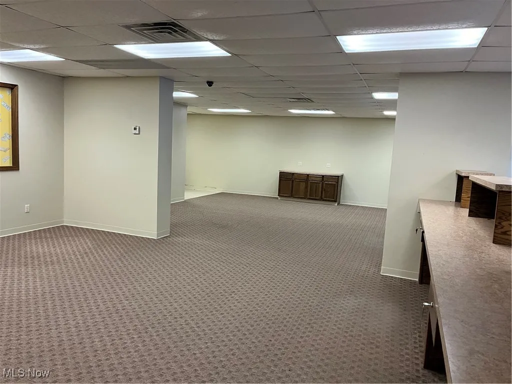Basement featuring carpet floors and a paneled ceiling