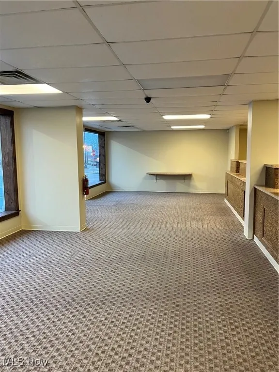 Basement with a drop ceiling and carpet floors