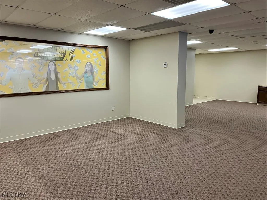 Basement with a drop ceiling and carpet floors