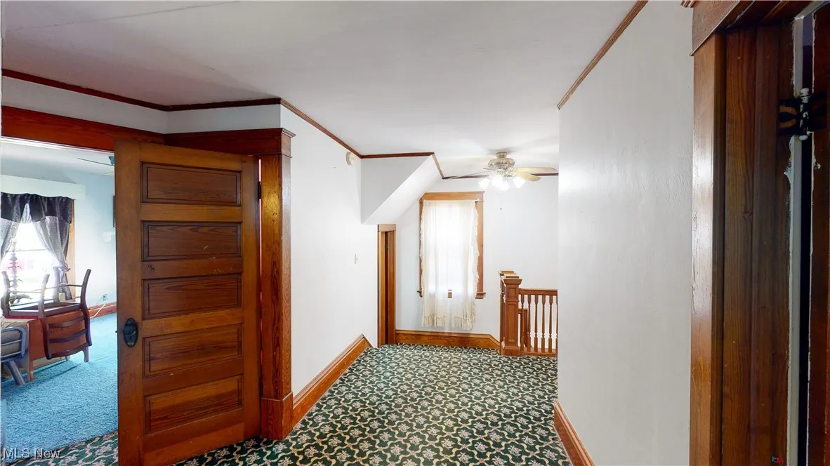 Hall featuring ornamental molding and carpet floors