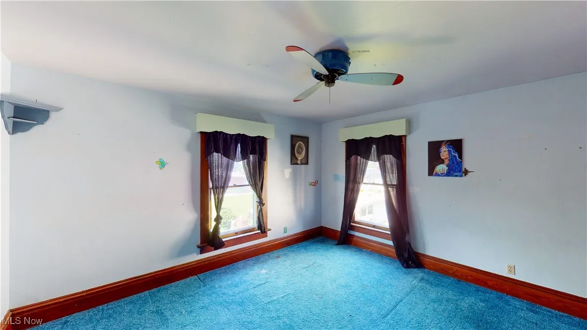Empty room featuring carpet and ceiling fan