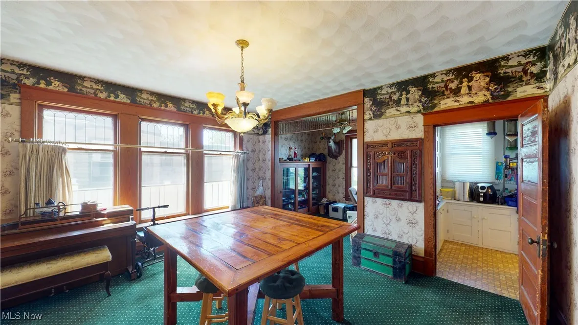 Dining area with a textured ceiling and an inviting chandelier