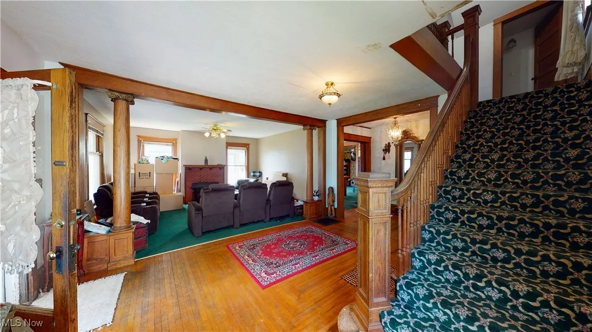 Living room with wood-type flooring and ornate columns