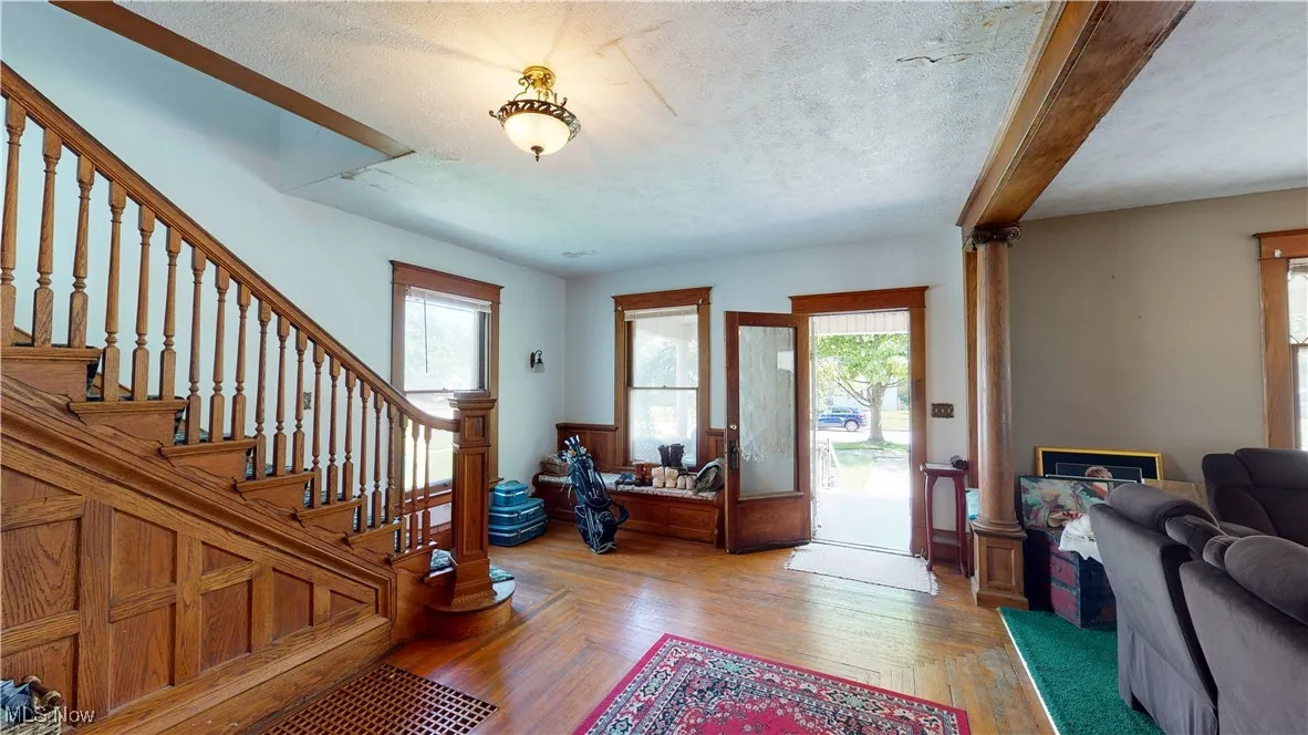 Entrance foyer featuring hardwood / wood-style floors, a wealth of natural light, and a textured ceiling