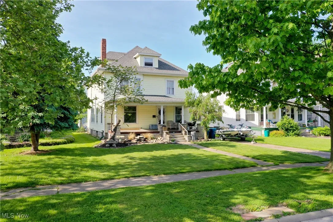 View of front facade with covered porch and a front lawn