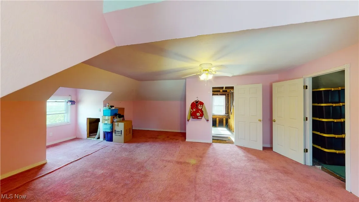 Additional living space featuring lofted ceiling, carpet floors, and ceiling fan