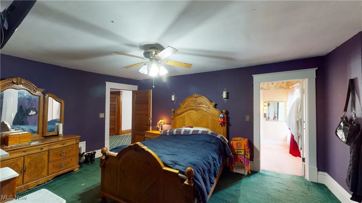 Carpeted bedroom featuring ceiling fan