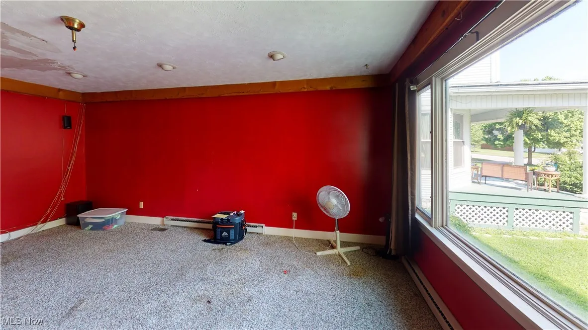 Spare room featuring baseboard heating and carpet floors
