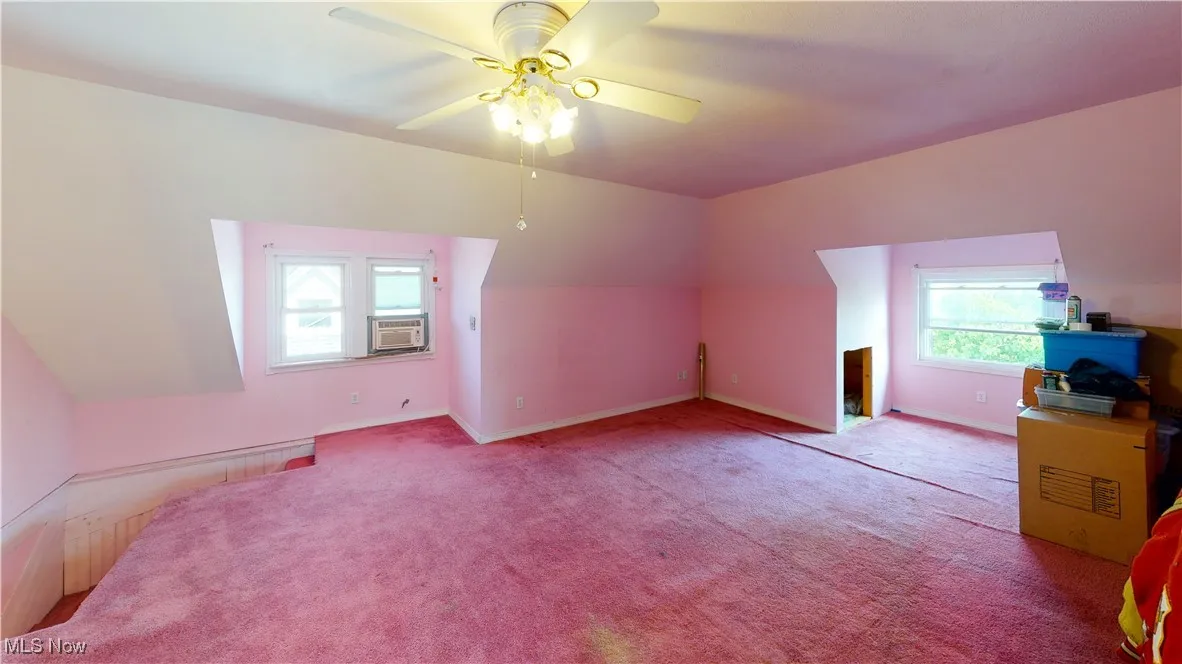 Bonus room featuring vaulted ceiling, light carpet, ceiling fan, and cooling unit