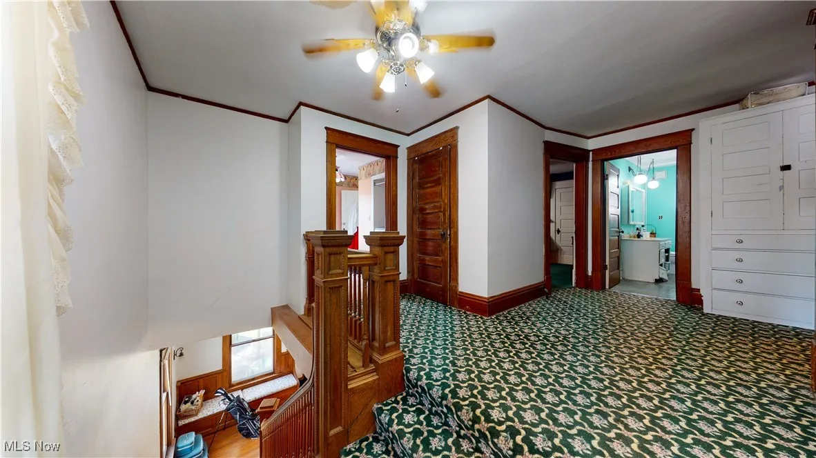 Hall with carpet floors and ornamental molding