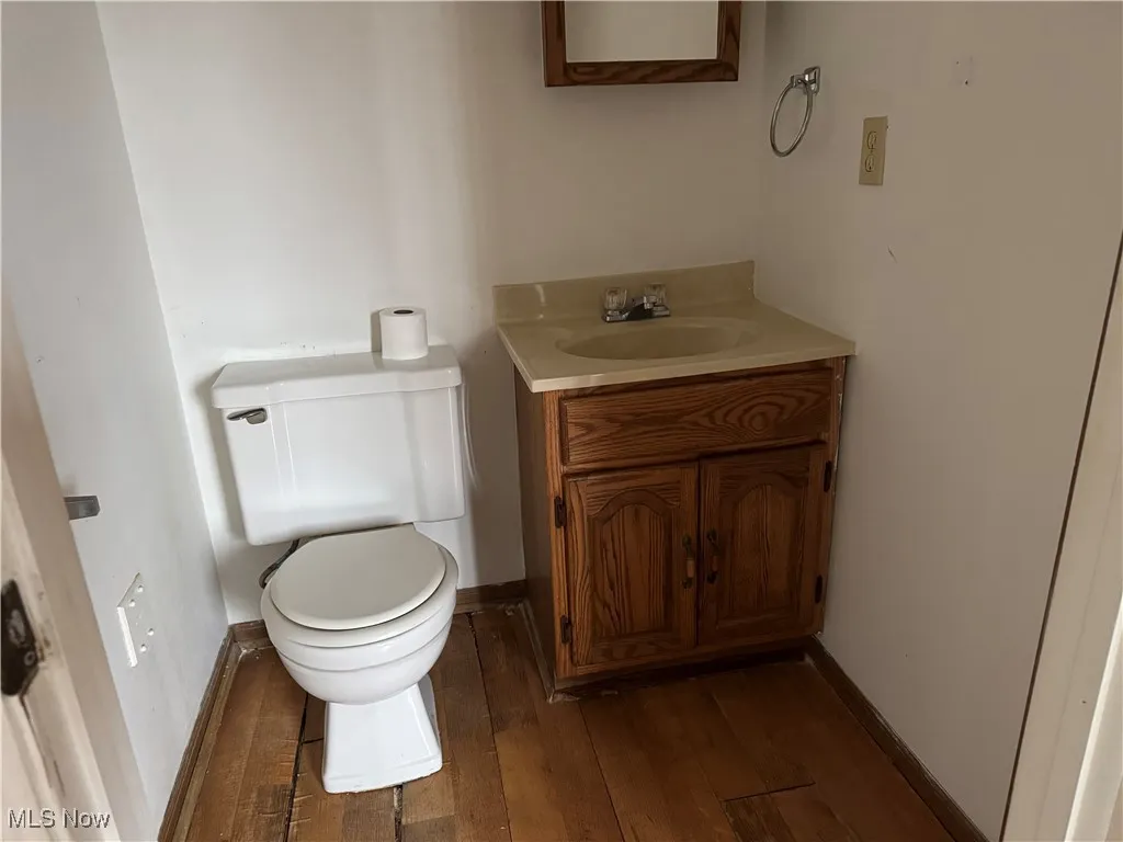 1st floor Bathroom featuring vanity, wood-type flooring, and toilet
