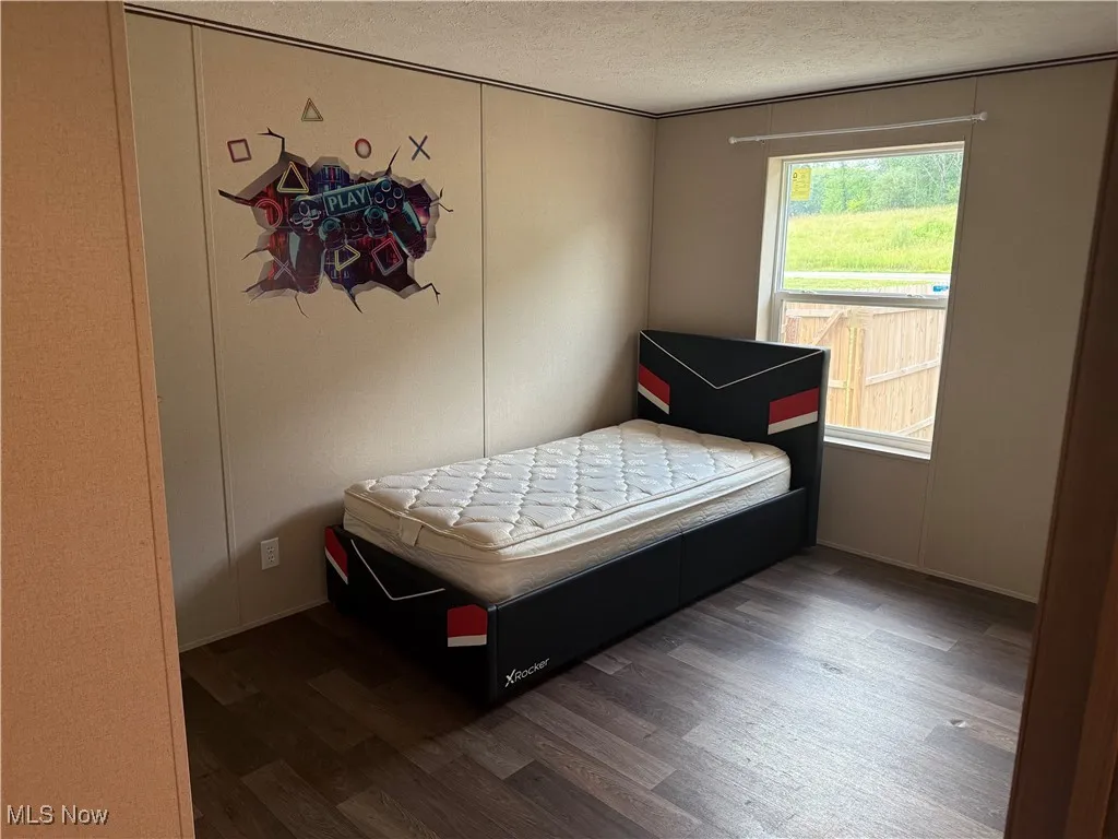 Bedroom featuring wood finished floors and a textured ceiling