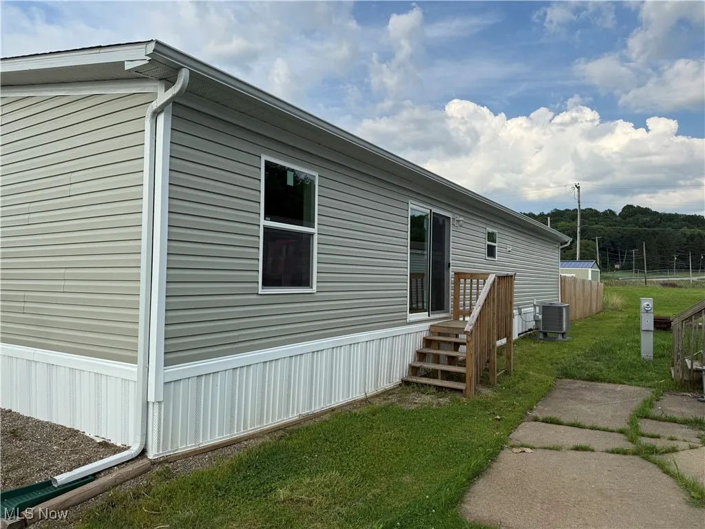 View of side of home with a central air condition unit