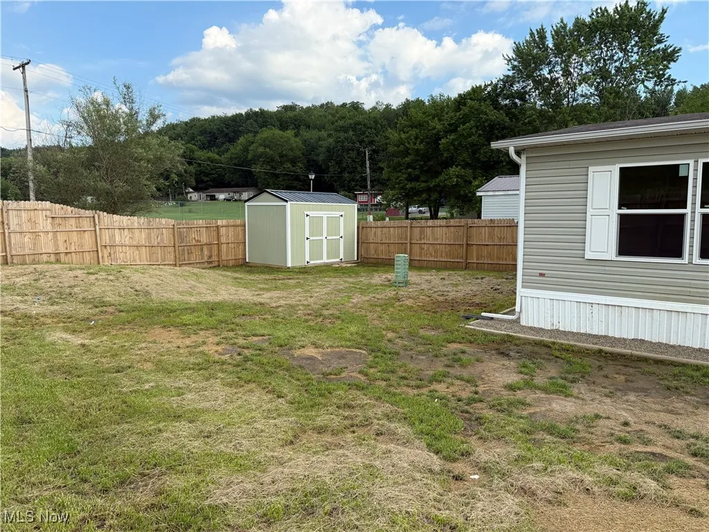 Fenced backyard with a storage shed