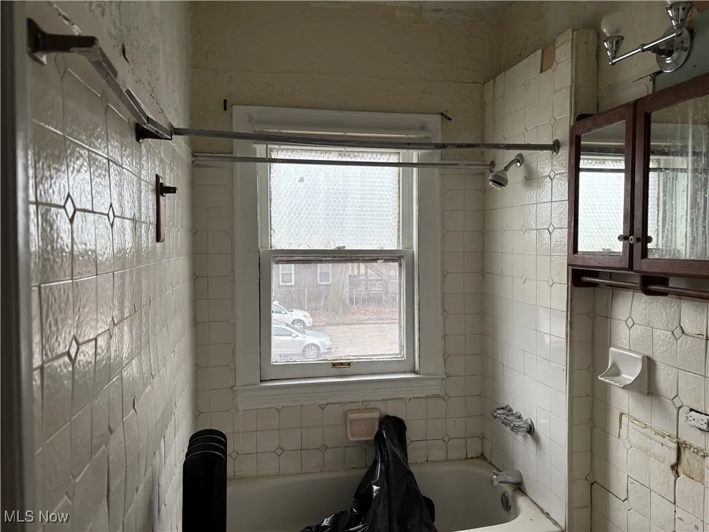 Bathroom with plenty of natural light and tiled shower / bath combo
