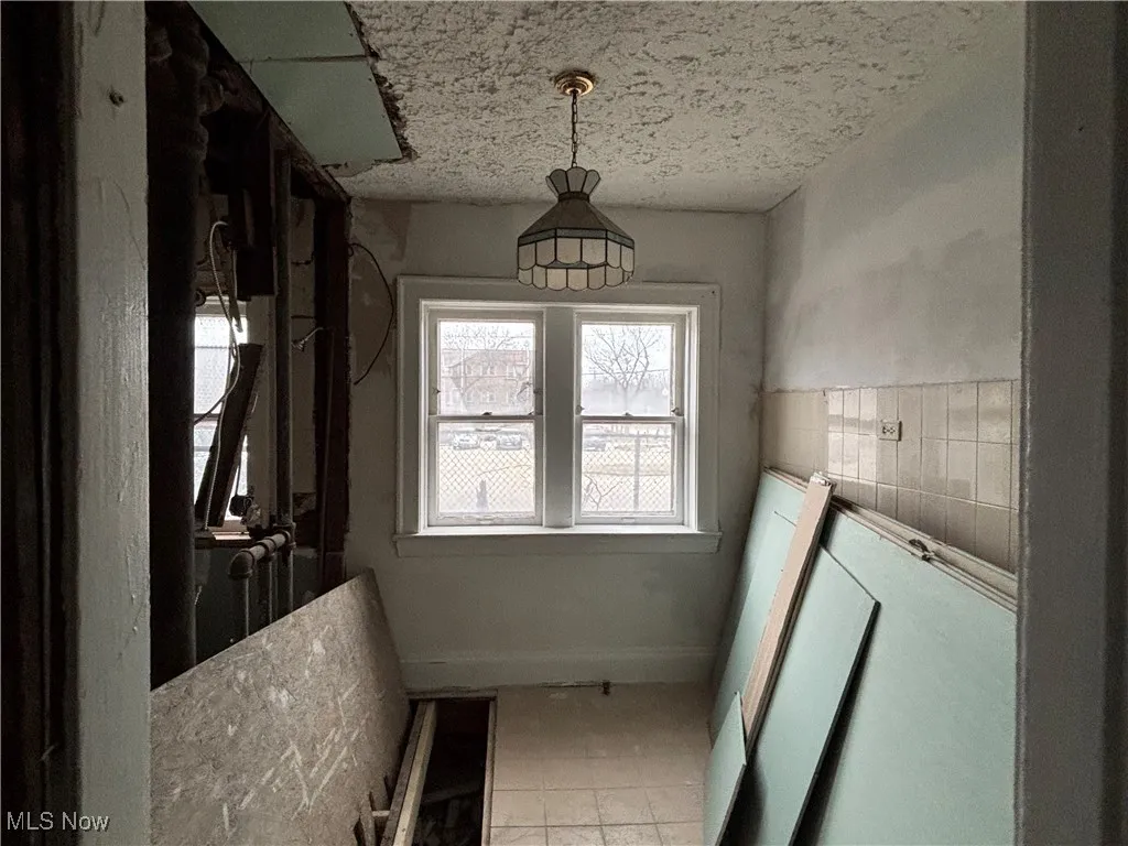 Bathroom with tile patterned flooring, tile walls, and a textured ceiling