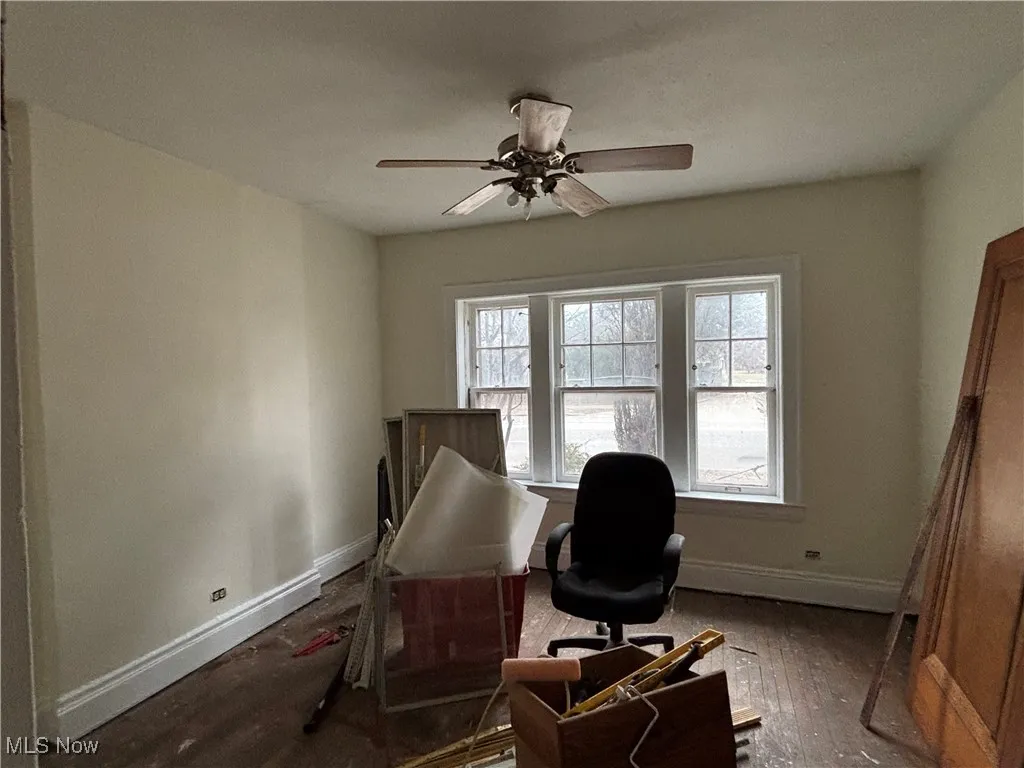 Home office featuring dark hardwood / wood-style floors and ceiling fan