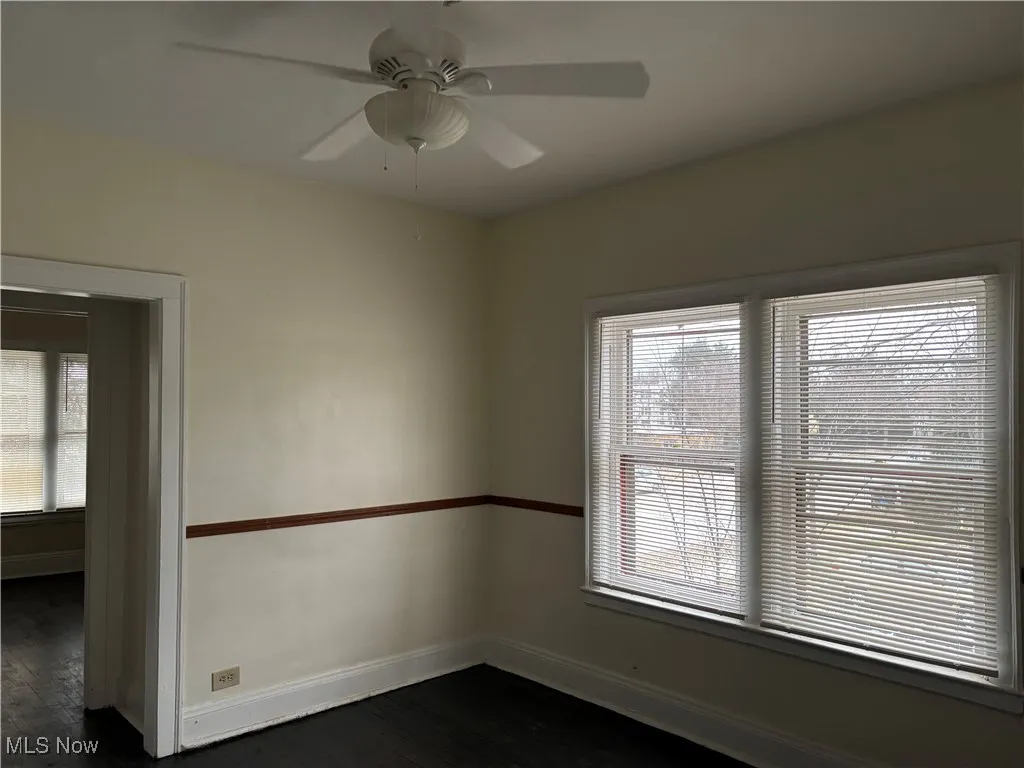 Unfurnished room featuring dark hardwood / wood-style floors and ceiling fan