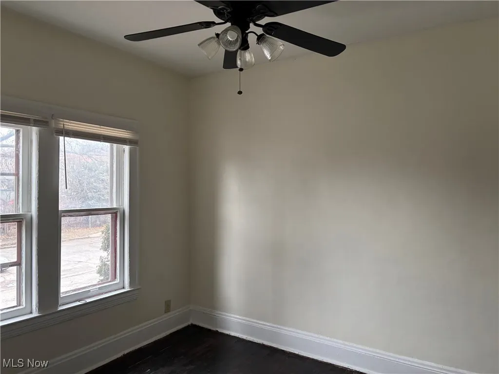 Empty room featuring dark hardwood / wood-style flooring