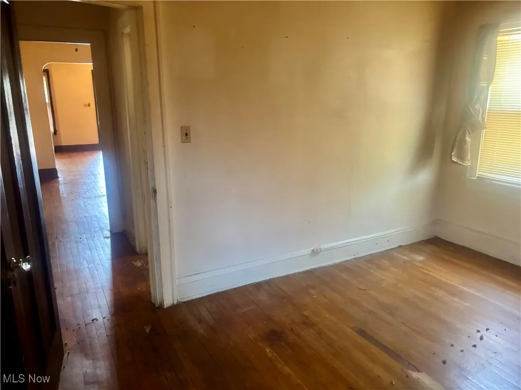 Empty room with baseboards and hardwood / wood-style floors