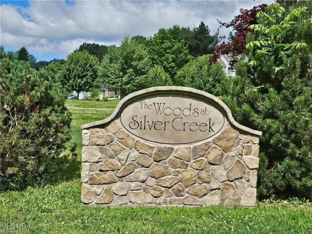 Community / neighborhood sign featuring a yard