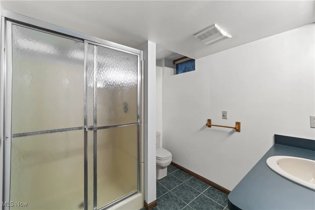 Large bedroom/library on the 1st floor with wood trim and wood paneling and a ceiling fan...Plenty of light with large windows !!!