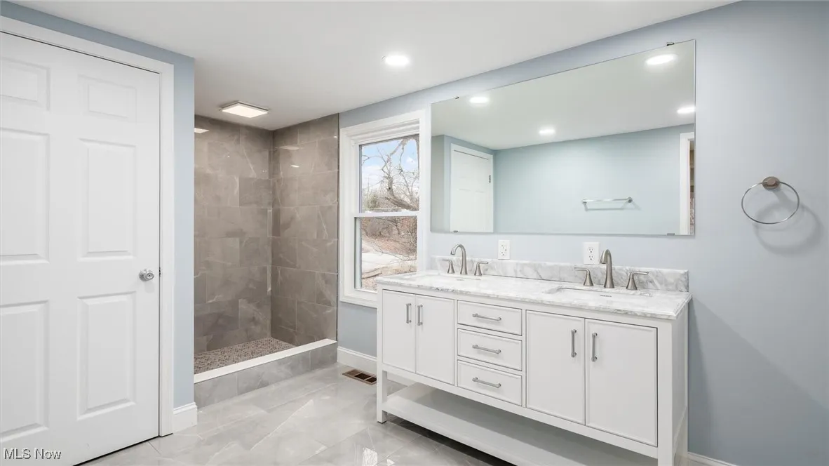 Bathroom with vanity and a tile shower