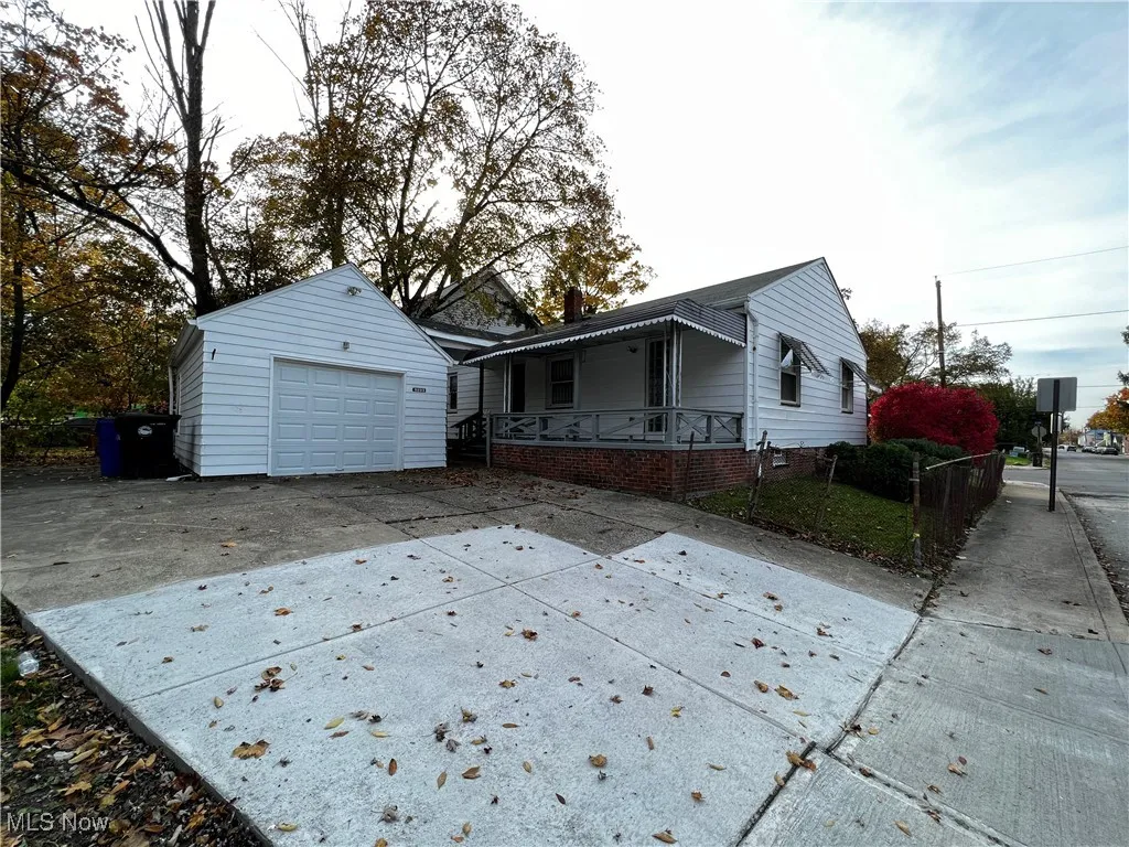 View of front of home featuring an outbuilding, a garage, and covered porch