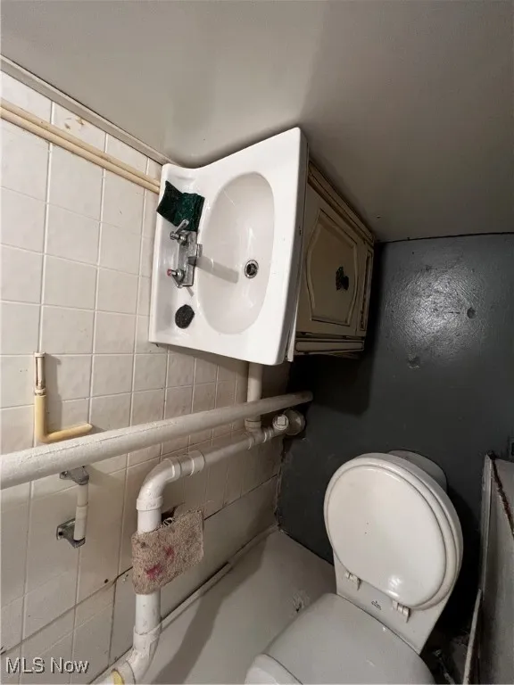 Bathroom with tasteful backsplash and toilet