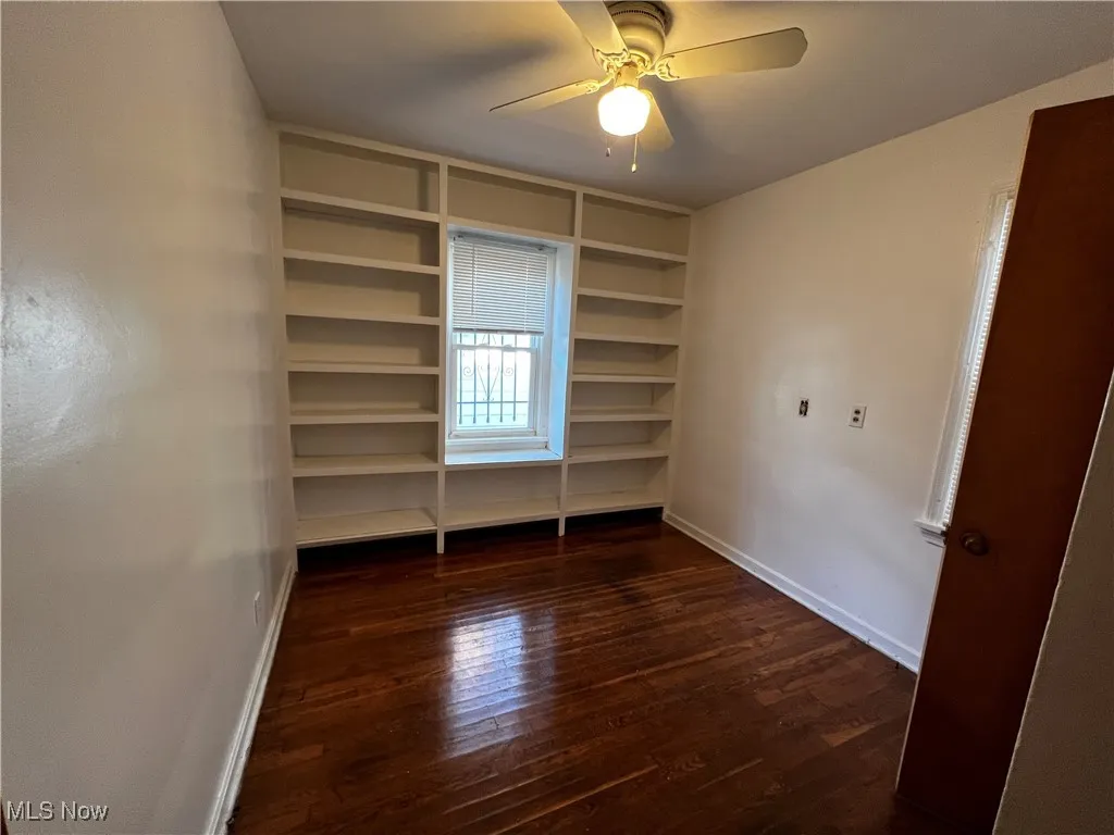 Unfurnished bedroom with dark wood-type flooring and ceiling fan