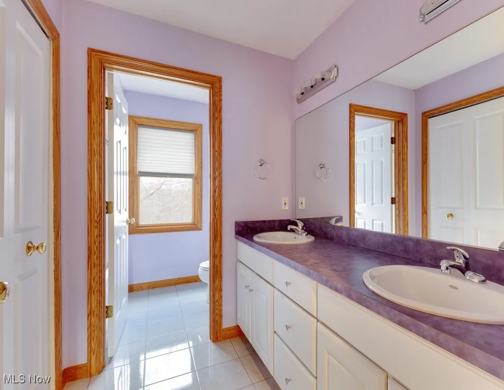 Bathroom featuring vanity, tile patterned floors, and toilet