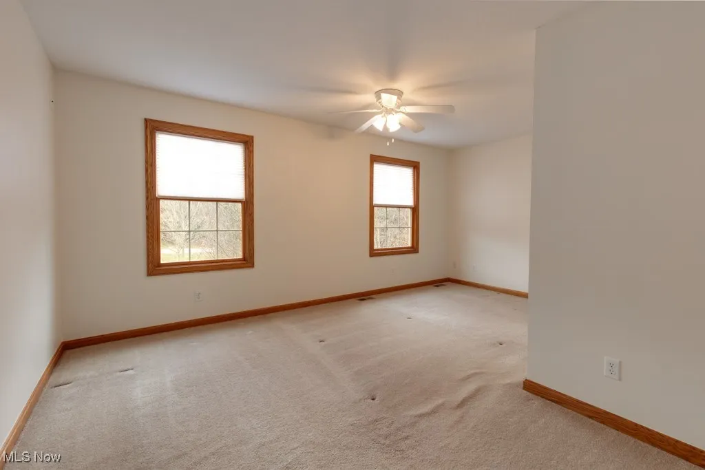 Carpeted spare room with ceiling fan