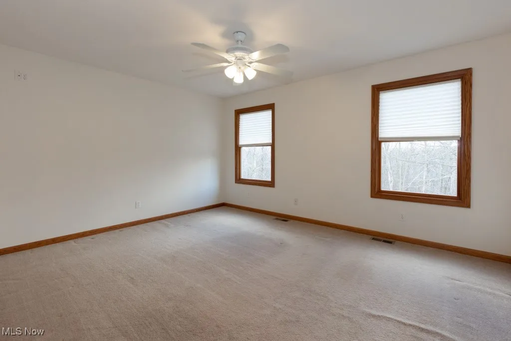 Spare room with light carpet and ceiling fan