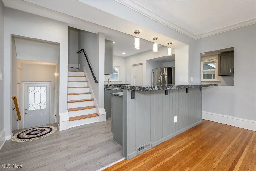 Kitchen featuring pendant lighting, sink, a breakfast bar area, stainless steel refrigerator, and kitchen peninsula