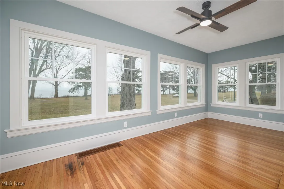 Unfurnished sunroom with ceiling fan