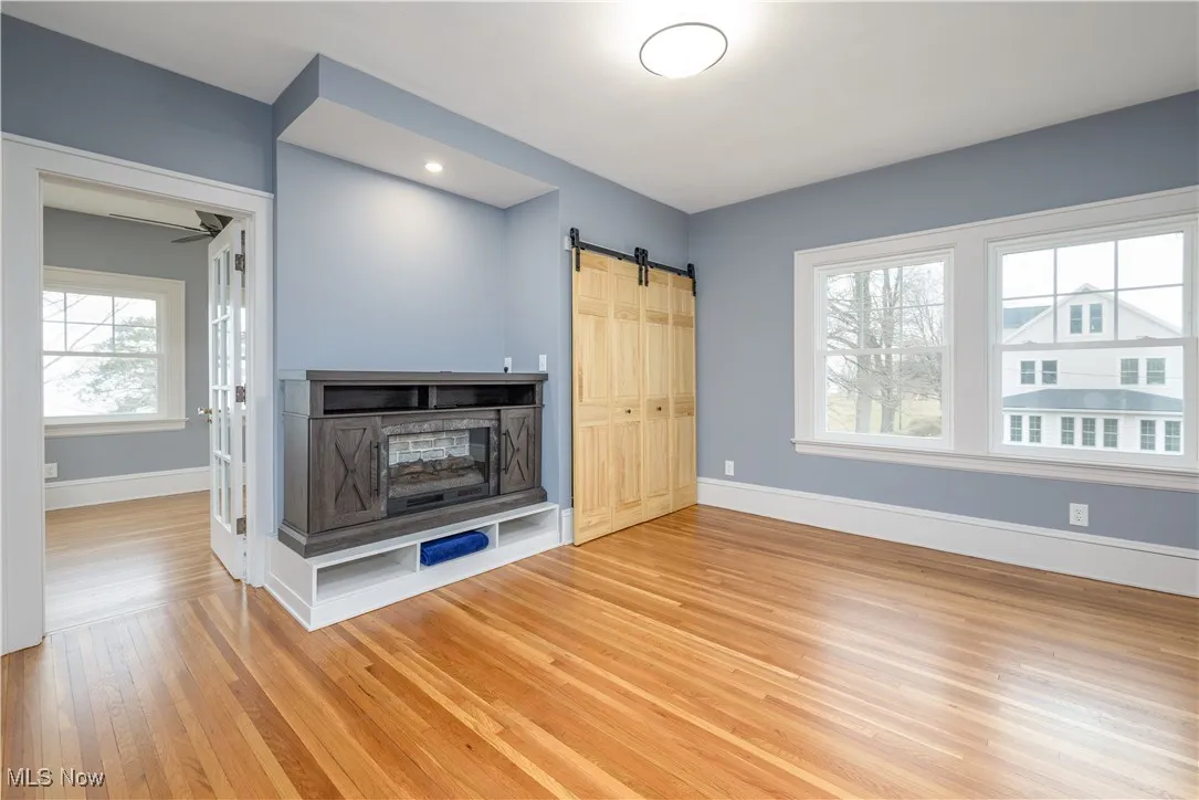 Unfurnished living room with wood-type flooring and a barn door