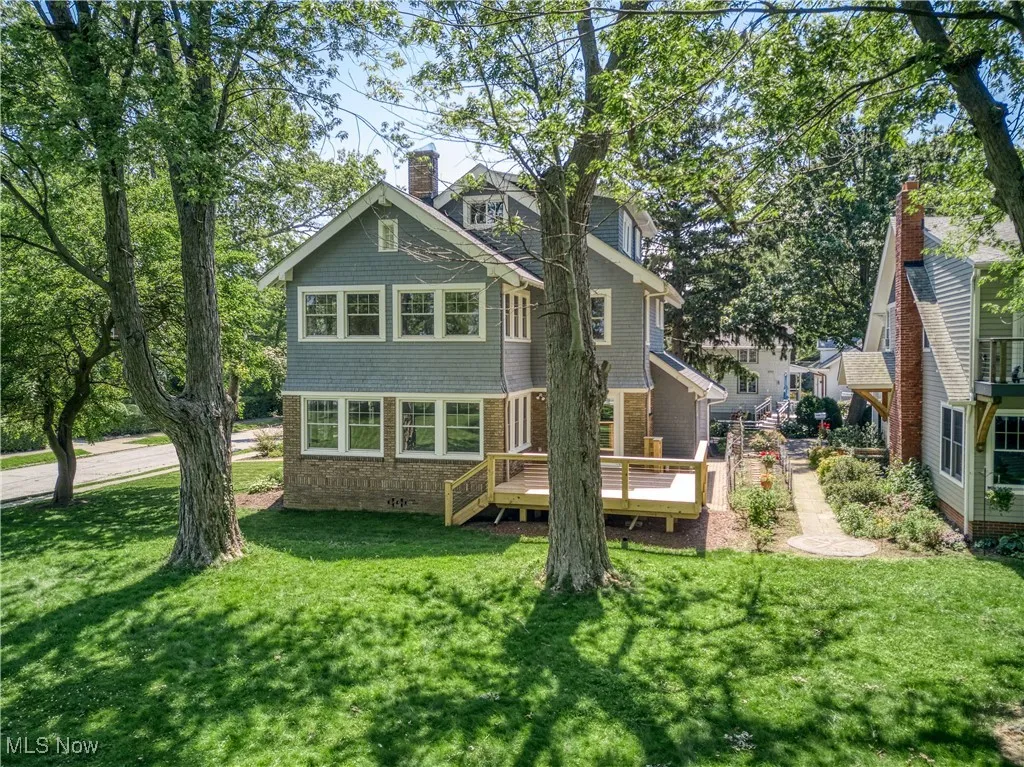 Back of house with a lawn and a wooden deck