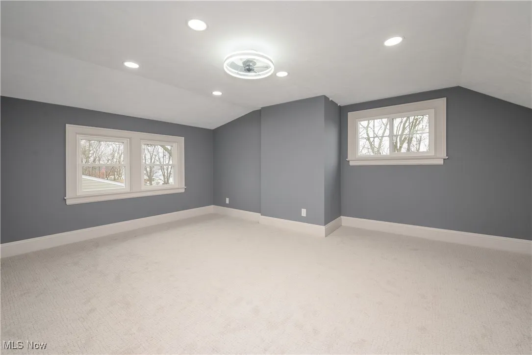 Bonus room featuring plenty of natural light, carpet flooring, and vaulted ceiling