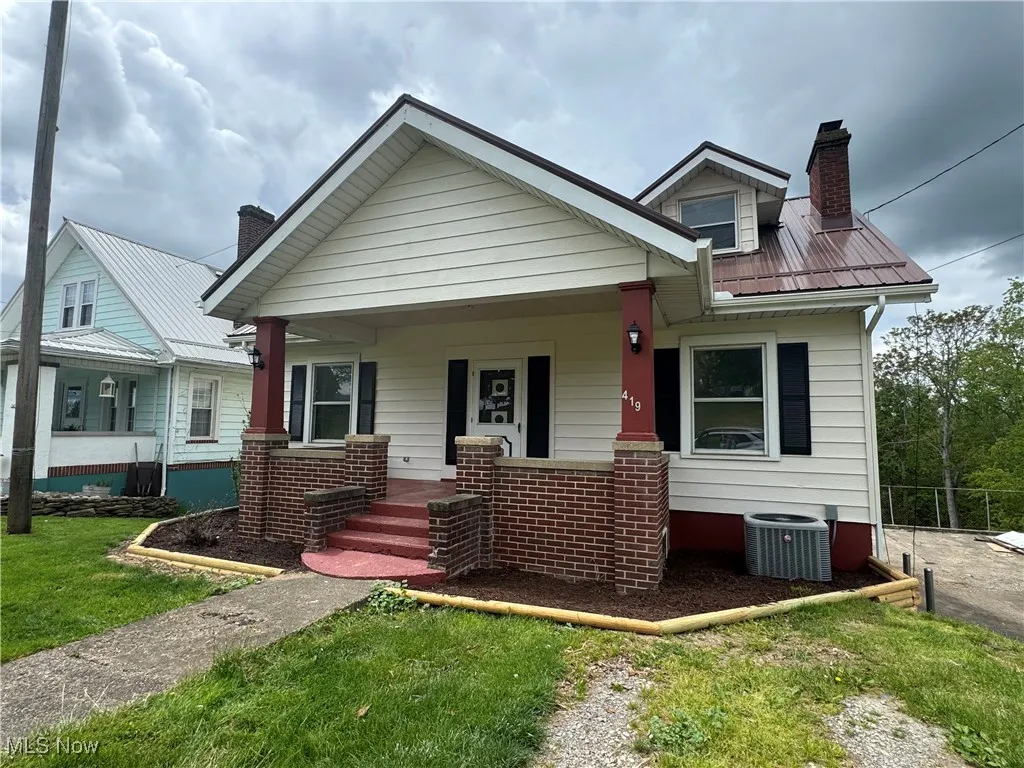 Bungalow featuring a chimney, a porch, central air condition unit, and metal roof