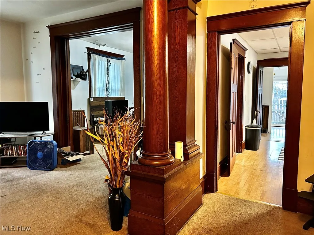 Hall with light carpet and a drop ceiling