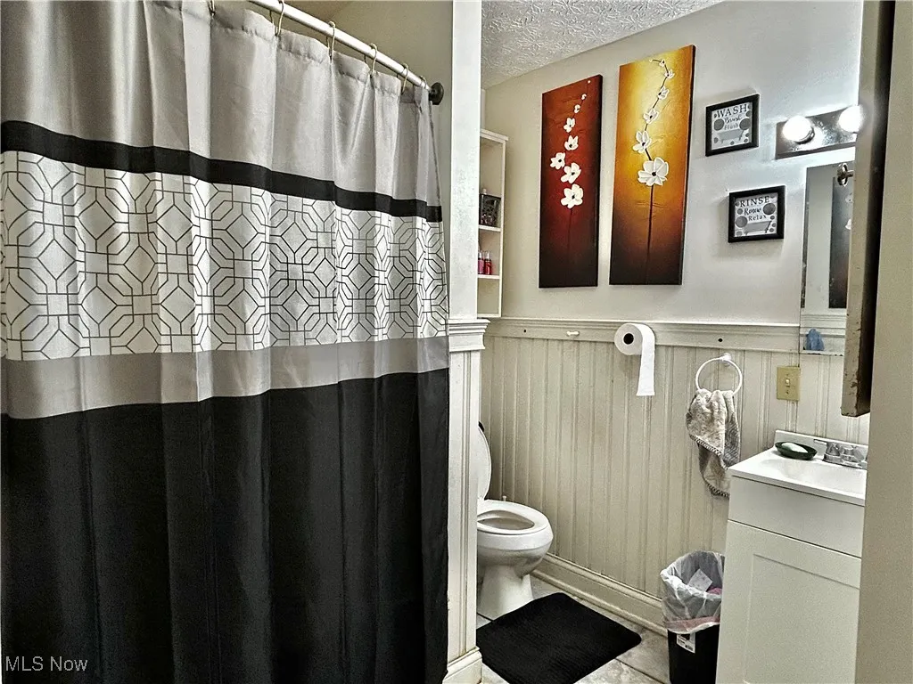Bathroom featuring vanity, toilet, and a textured ceiling