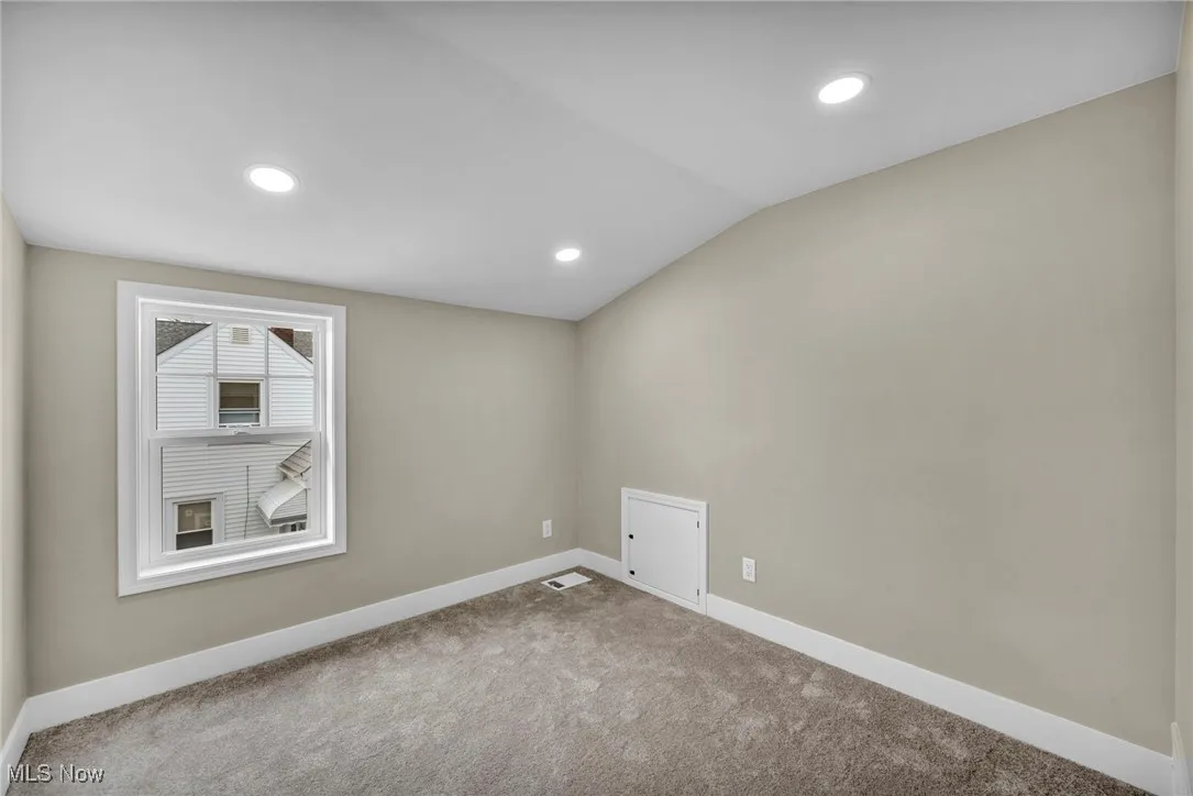 Empty room featuring lofted ceiling and carpet floors