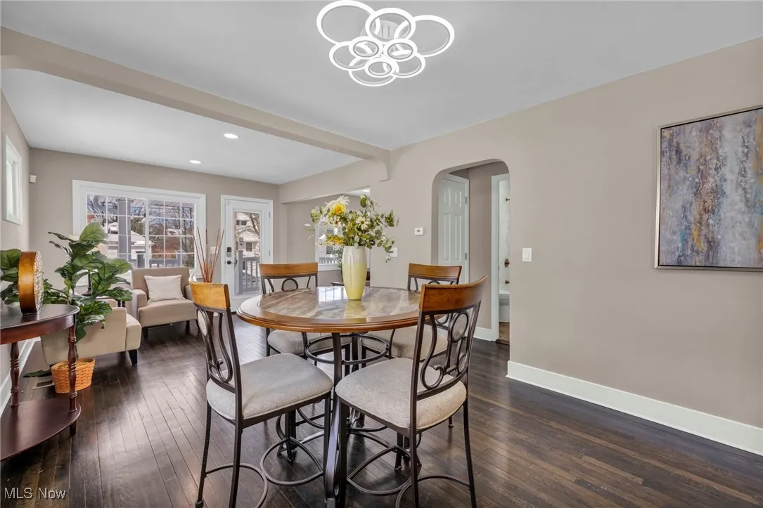 Dining space featuring recessed lighting, baseboards, arched walkways, and dark wood finished floors