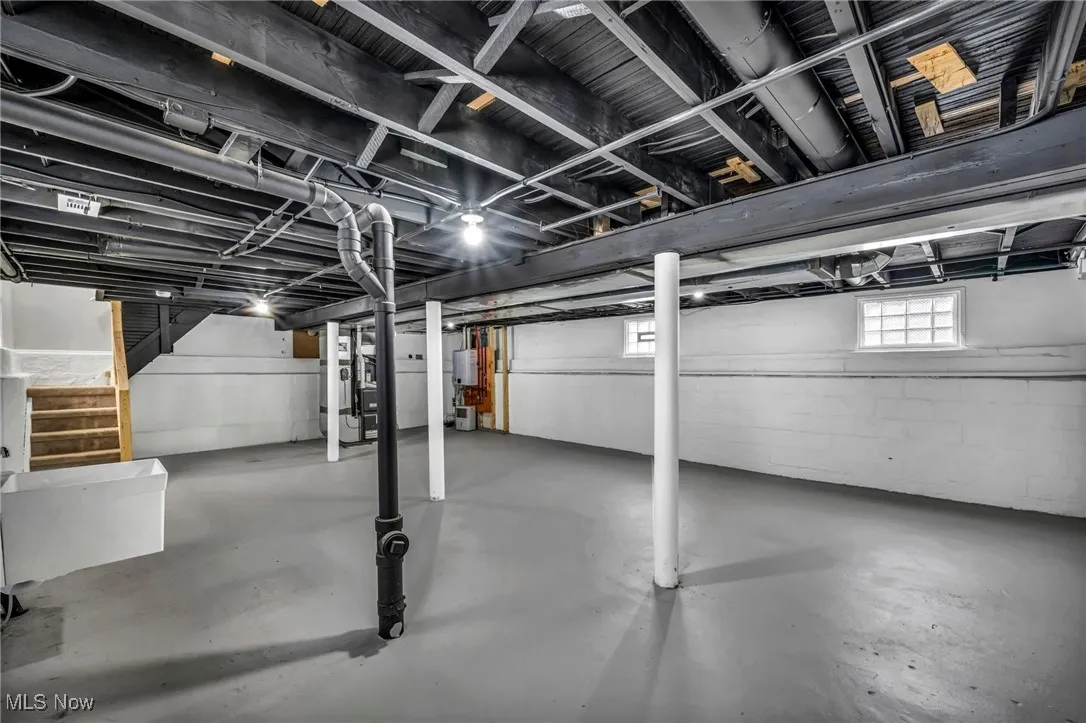 Basement featuring water heater and heating unit