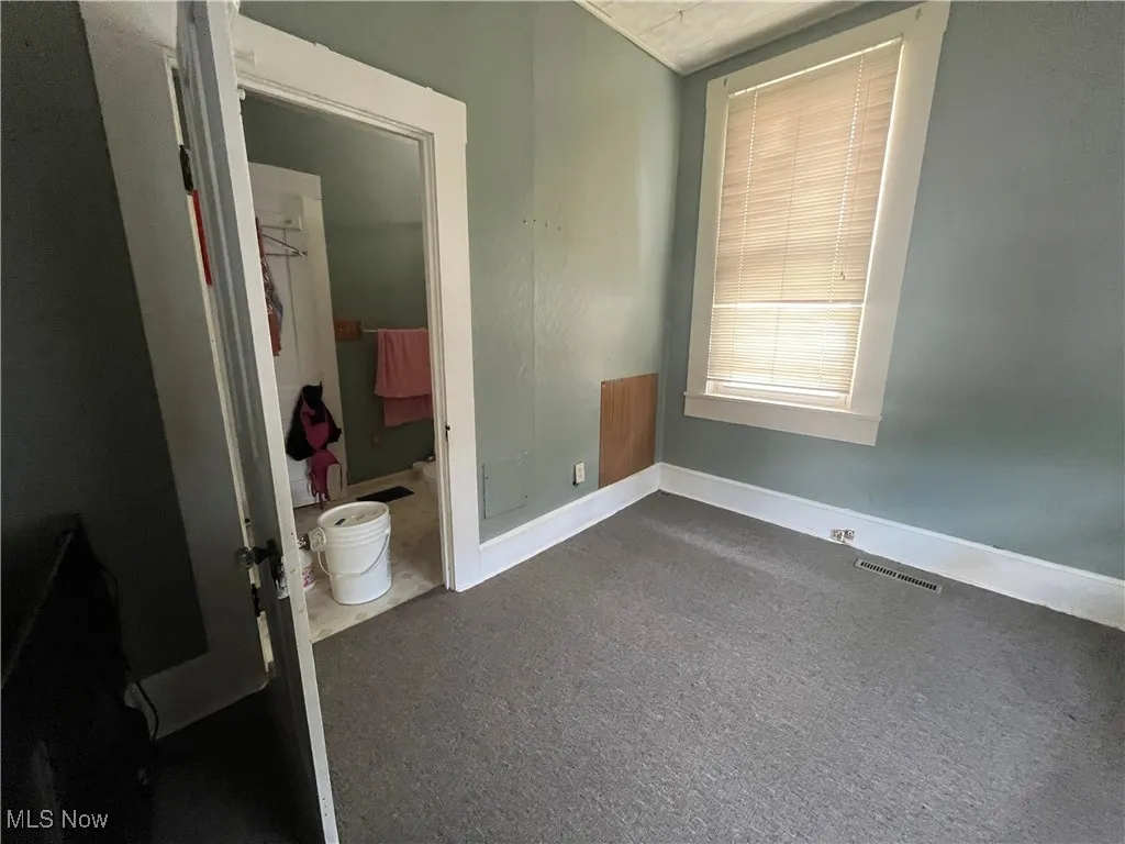 Unfurnished bedroom featuring ensuite bath and carpet floors