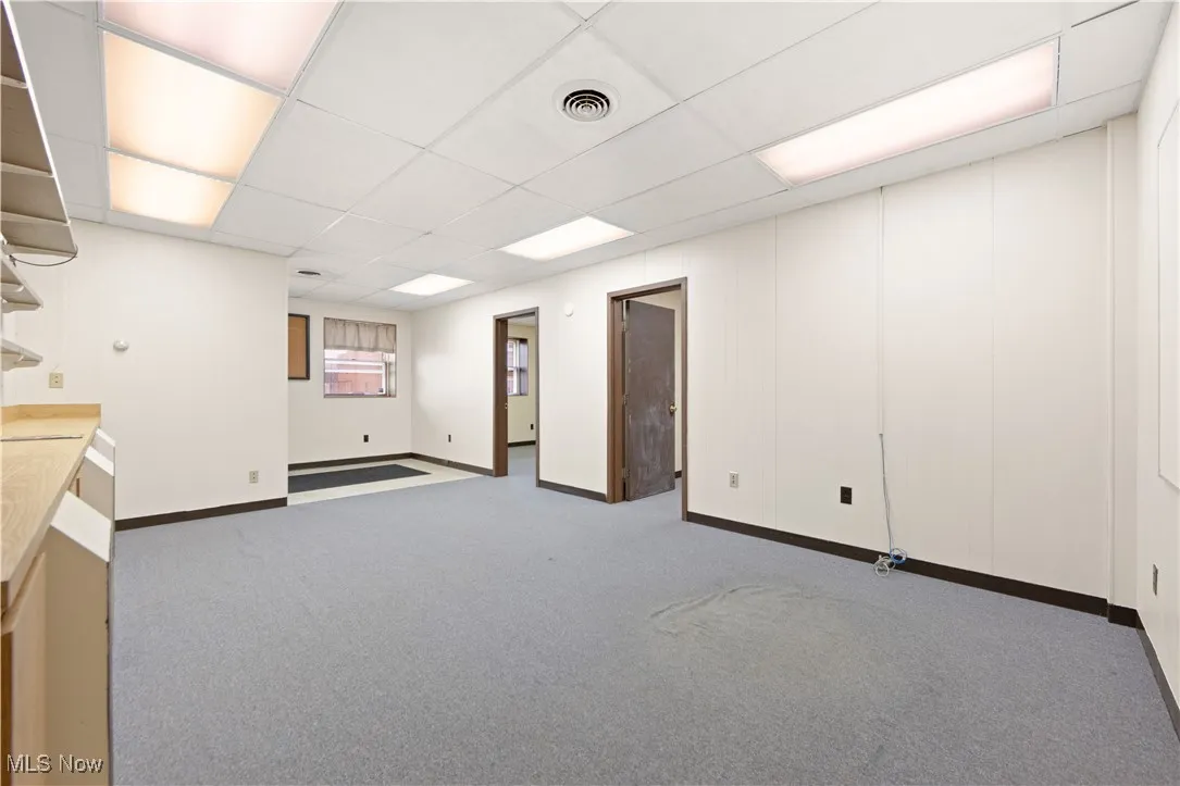 Basement with a drop ceiling and carpet
