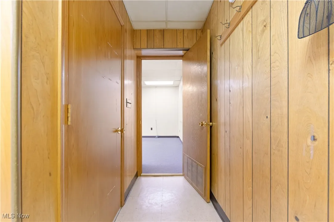 Corridor featuring wooden walls