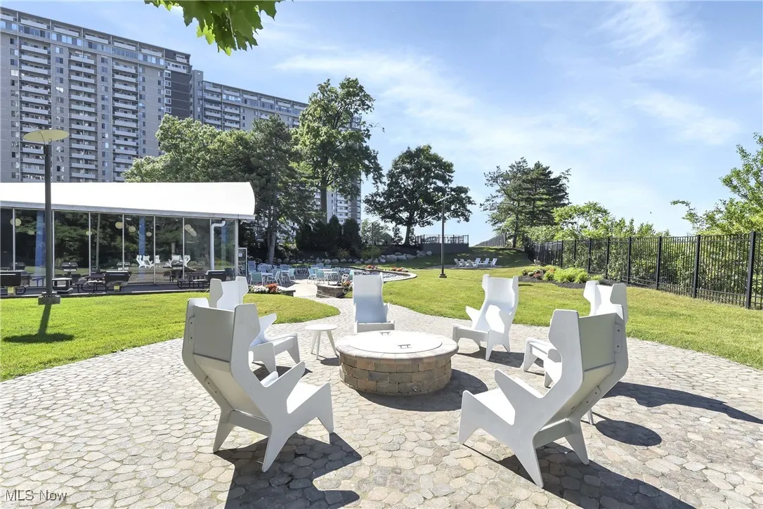 View of community with a fire pit, a patio area, and a lawn