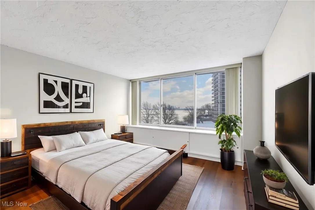 Bedroom featuring dark hardwood / wood-style flooring and a textured ceiling