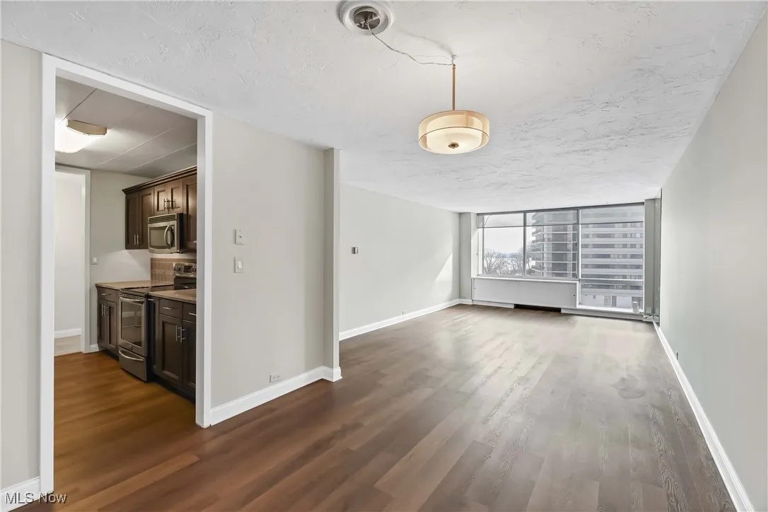 Unfurnished room with a textured ceiling and dark hardwood / wood-style flooring
